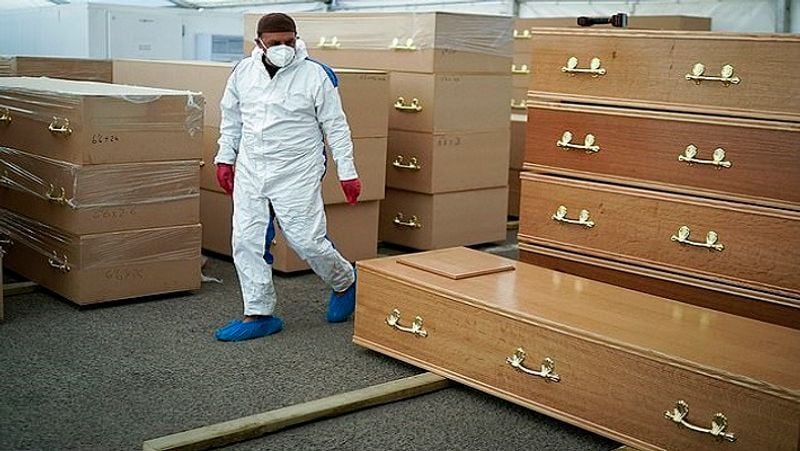 In an image, specially trained staff wearing personal protective equipment (PPE) were seen removing transparent plastic sheets around the coffins and inspecting them.
