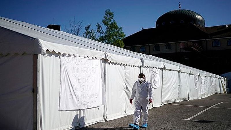 A specially trained volunteer wearing protective clothing circulates the temporary tent at the Central Jamia Mosque Ghamkol Sharif.
