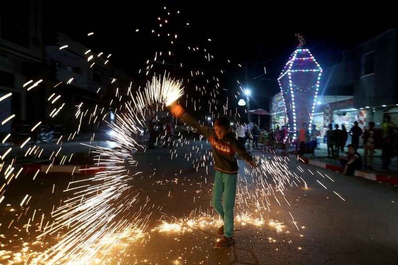 റമദാന് ആഘോഷത്തിന്റെ ഭാഗമായി പലസ്തീനിലെ തെക്കൻ ഗാസയിൽ ഒരു കുട്ടി പടക്കം പൊട്ടിച്ച് ആഘോഷിക്കുന്നു.