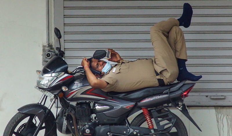 यह तस्वीर देश की राजधानी दिल्ली की है, जहां एक पुलिसकर्मी लॉकडाउन में ड्यूटी के दौरान कुछ थकान मिटाने के लिए बाइक पर ही आराम करने लगा। 