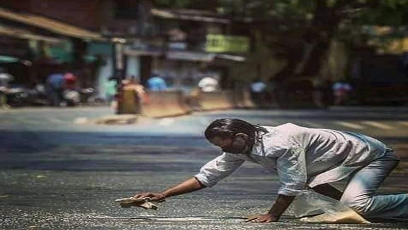 सड़क पर बिखरे चावल चुन कर प्लास्टिक की थैली में रखता शख्स। यह कई दिनों से भूखा था। इसकी फोटो सोशल मीडिया पर वायरल हो गई। 