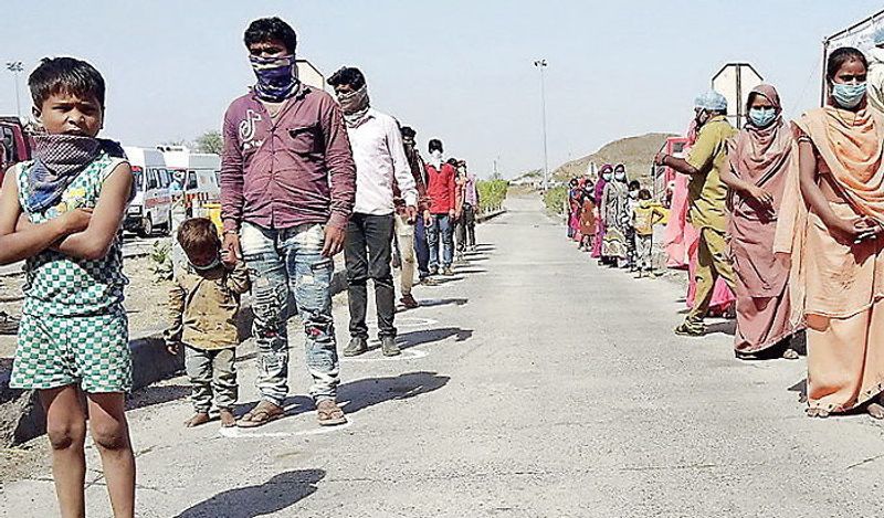 यह तस्वीर गुजरात के दहोद जिले की है, जहां राज्य की बॉर्डर पर मजदूर स्क्रीनिंग कराने के लिए 37 डिग्री तापमान में बच्चे के साथ नंगे पैर लाइन में खड़े हैं।