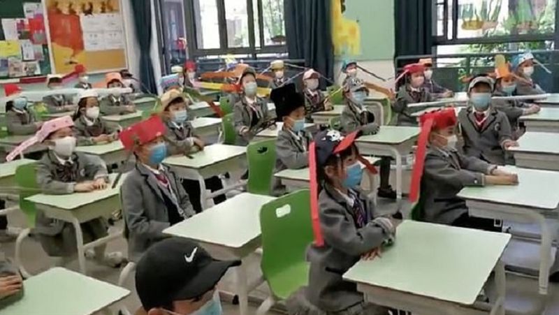 स्कूल जाने वाले बच्चों को घर में बनाई गई एक खास टोपी पहनने को दी गई है, जिसमें लंबी स्टिक लगी हुई है। इससे बच्चे एक-दूसरे के करीब नहीं आ पाएंगे। साथ ही, सभी बच्चों को मास्क पहनने के लिए दिया गया है। 