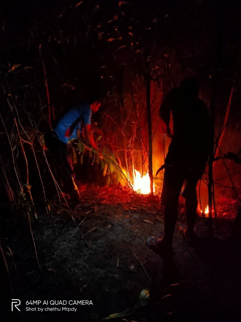 ಬೆಂಕಿ ನಂದಿಸುವ ಕೆಲಸದಲ್ಲಿ ಯುವಕರು ತಲ್ಲೀನರಾಗಿರುವುದು