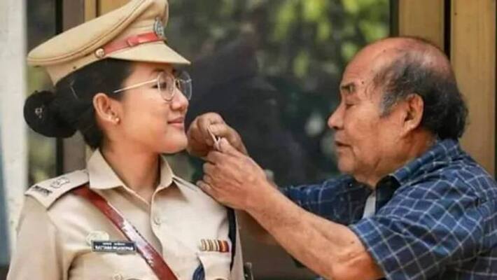 A proud father check the stars of cop daughter's uniform A proud father check the stars of cop daughter's uniform