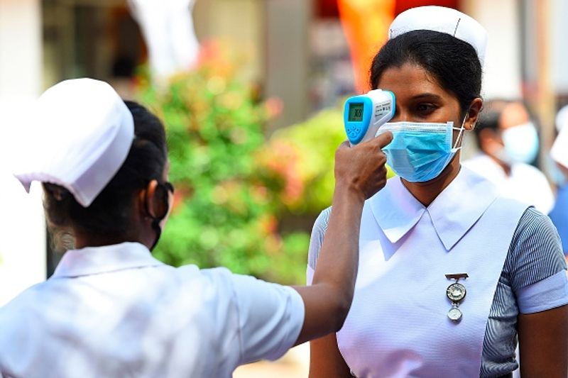 ശ്രീലങ്കയിലെ ഒരു ആശുപത്രിയിൽ സഹപ്രവർത്തകയുടെ ടെംപറേച്ചർ പരിശോധിക്കുന്ന നഴ്സ്