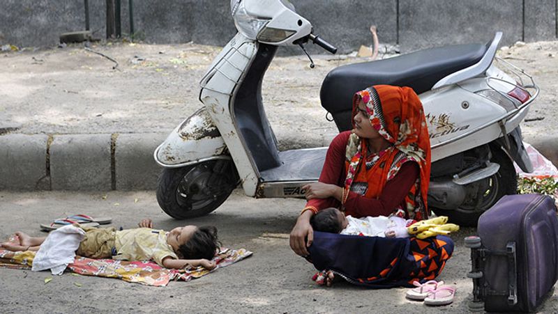 गाजियाबाद से मध्य प्रदेश के लिए निकलते समय चेकिंग पाइंट पर अपनी बारी का इंतजार करती एक मां।