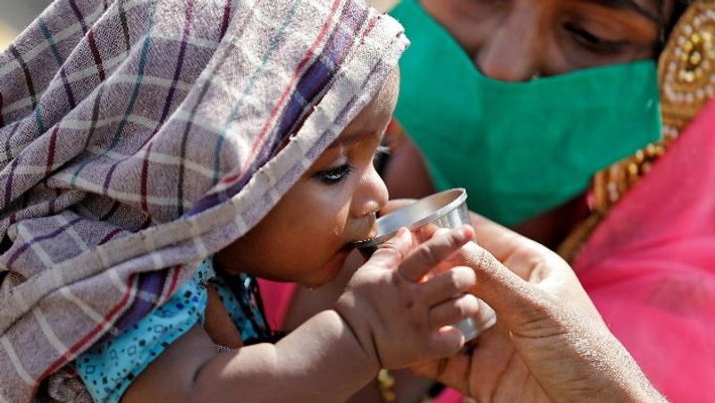 लॉकडाउन में घर लौटते और संघर्ष करते मजदूरों की यह तस्वीर अहमदाबाद में रेलवे स्टेशन की है। जहां एक मां सैकंड़ों मील पैदल चलने के बाद अपने प्यासे बेटे को पानी पिला रही है।