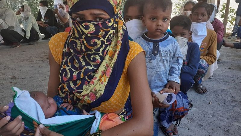 तस्वीर में दिखाई से रही इस मजदूर महिला का नाम नीतू देवी है, वह हरियाणा के जींद से अपने घर यूपी आजमगढ़ जान के लिए तीखी धूप में बैठी है। वह गोद में अपनी बच्ची को लिए हुए है।