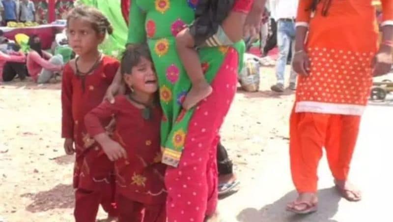 यह तस्वीर राजस्थान के भरतपुर से सामने आई है। जहां यह मासूम बच्चे चिलचिलाती धूप के बीच नंगे पैरों से तपती सड़क पर चलने को मजबूर हैं। मासूम चीख रहा है, फिर उसकी मां हाथ पकड़े हुए उसे घसीट रही है। एक हाथ में महिला ने अपने दूसरे बच्चे को पकड़ रखा है।