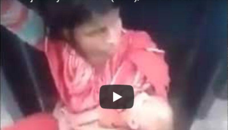 Video of mother sitting between train carriages with infant