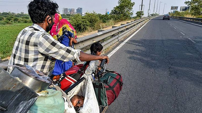 इस मजदूर के साथ गर्म तपती सड़क पर कुछ बच्चे नंगे पैर भी चल रहे हैं। उनमें से एक बच्ची अपने पिता की साइकिल पर धक्का लगा रही है।