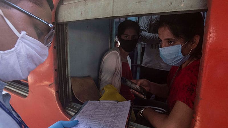पुणे से जाती एक ट्रेन में पैसेंजर की लिस्ट चेक करता टिकट चेकर।
