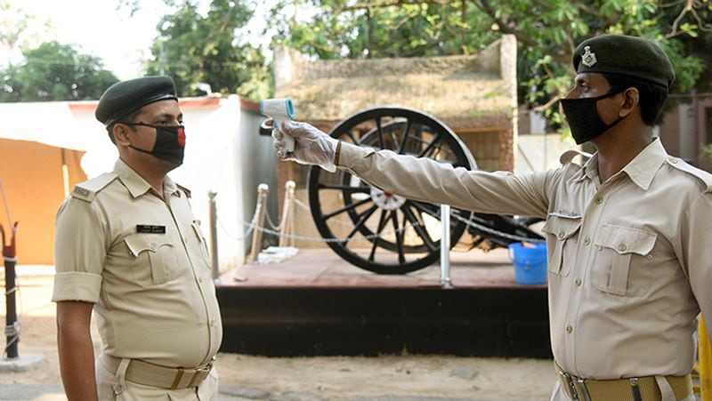 यह तस्वीर पटना की है। एक पुलिसवाला दूसरे का तापमान चेक करता हुआ।