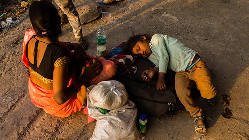 यह तस्वीर नई दिल्ली की है। घर वापसी के लिए गाड़ी के इंतजार में बैठी मां के पास यूं सो गई बच्ची।