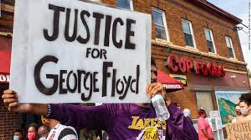 People hold a banner 'Justice for George Floyd'.