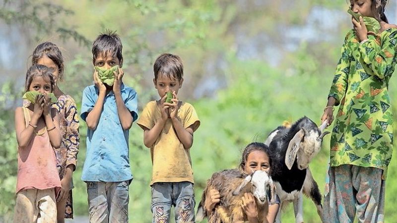 दरअसल, यह तस्वीर बांसबाड़ा जिले की है, जिसको फोटोग्राफर भरत कंसारा ने अपने कैमरे में कैद की है। यह बच्चे गांव में एक तलाब किनारे खेल रहे थे, उनके हाथों में बड़े-बड़े पत्ते थे, जब उनसे पत्रकार ने पूछा इनका क्या करोगे तो मासूम कहने लगे इन पत्तों से हम मास्क बनाएंगे। फिर उससे अपना चेहरा ढकेंगे, ताकि हमको कोरोना ना हो। यह बच्चे अपनी वागड़ी भाषा में एक-दूसरे से बात कर रहे थे,‘मोड़को बंद कर, ने तो कोरोनू पैई जाइगा’यानी इन पत्तों से मुंह ढ़क लोग वरना कोरोना हो जाएगा।