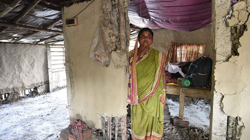 तूफान से बर्बाद हुए अपने घर के बाहर मायूस खड़ी महिला। यह प्राकृतिक आपदा कइयों की जिंदगी पर काल बनकर टूटी।