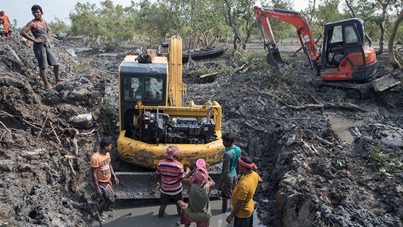 पश्चिम बंगाल के जरखाली में तूफान से भरे पानी की निकासी का प्रबंध करती रेस्क्यू टीम।