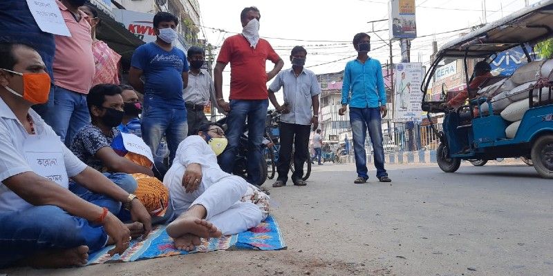 বৃহস্পতিবার ভরদুপুরে রায়গঞ্জে দলের জেলা কার্যালয়ের সামনে অভিনব কায়দায় প্রতিবাদ কর্মসূচিতে শামিল হন বিজেপি জেলা সভাপতি বিশ্বজিৎ লাহিড়ি।