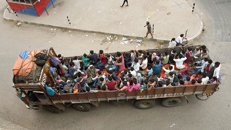 एक ट्रक पर ठसाठस बैठे लोग।
