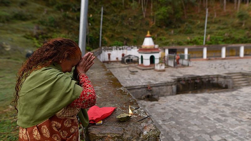 काठमांडु नेपाल में लॉकडाउन के चलते बाहर से भगवान के दर्शन करती एक महिला।