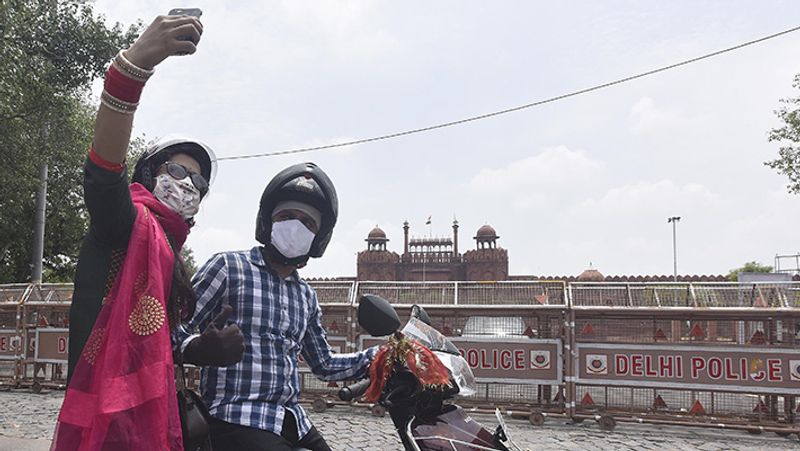 नई दिल्ली में लाल किले के पास सेल्फी लेता एक कपल।