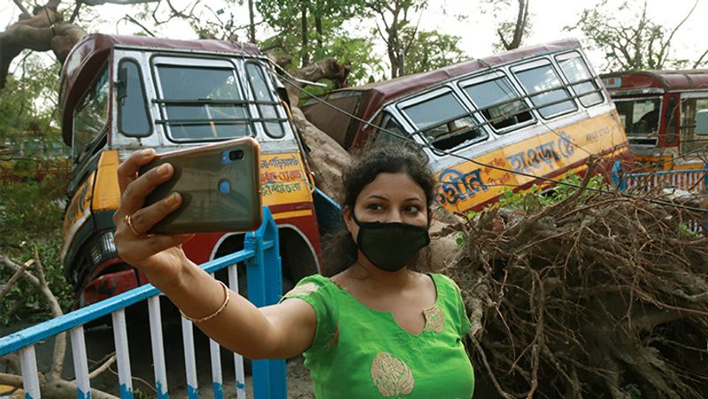 पश्चिम बंगाल में पिछले दिनों आए अम्फान तूफान के बाद सेल्फी लेती एक युवती।