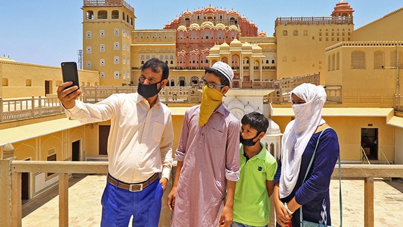 जयपुर में हवा महल घूमने आया एक परिवार सेल्फी लेते हुए।