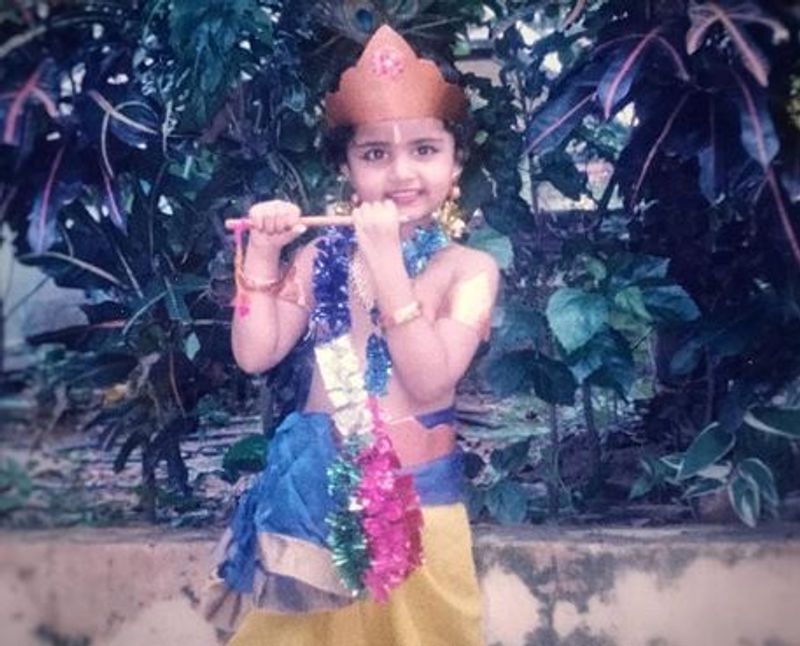 இது யாருனு தெரியுதா? குட்டி கிருஷ்ணனாக, கியூட் சிரிப்பில் புல்லாங்குழல் வைத்து கொண்டு போஸ் கொடுப்பது வேறு யாரும் இல்லை, சுருட்டை முடி அழகி 'கொடி' பட நடிகை சுழலி தான்.