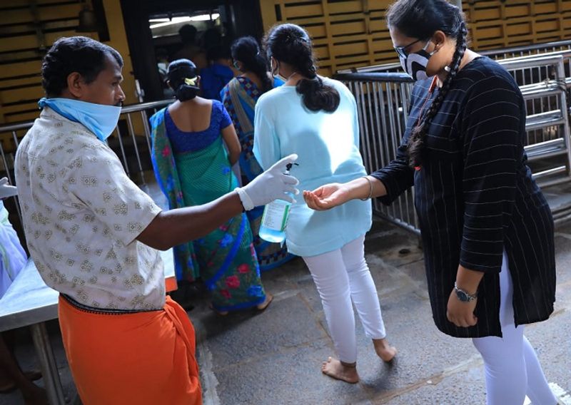 ಭಕ್ತರಿಗೆ ದೇವಾಯಲ ಪ್ರವೇಶಿಸುವಾಗ ಸ್ಯಾನಿಟೈಸರ್ ನೀಡುತ್ತಿರುವುದು