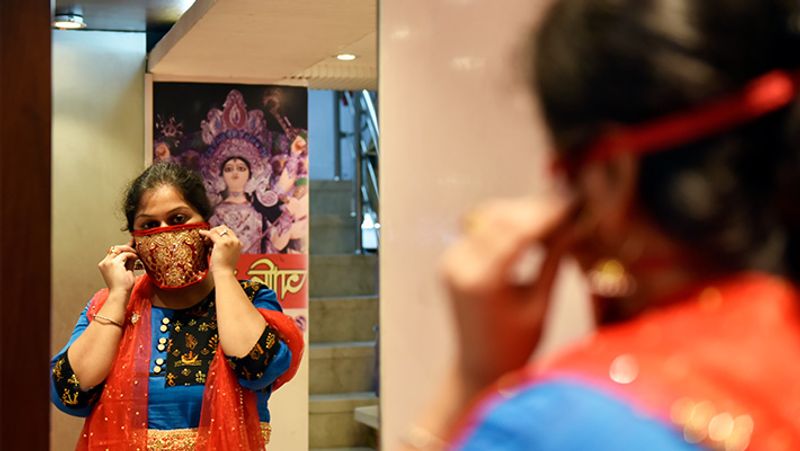 दुल्हनों के लिए बाजार में डिजाइनर मास्क आ गए हैं। कोलकाता में एक दुकान पर मास्क देखती महिला।