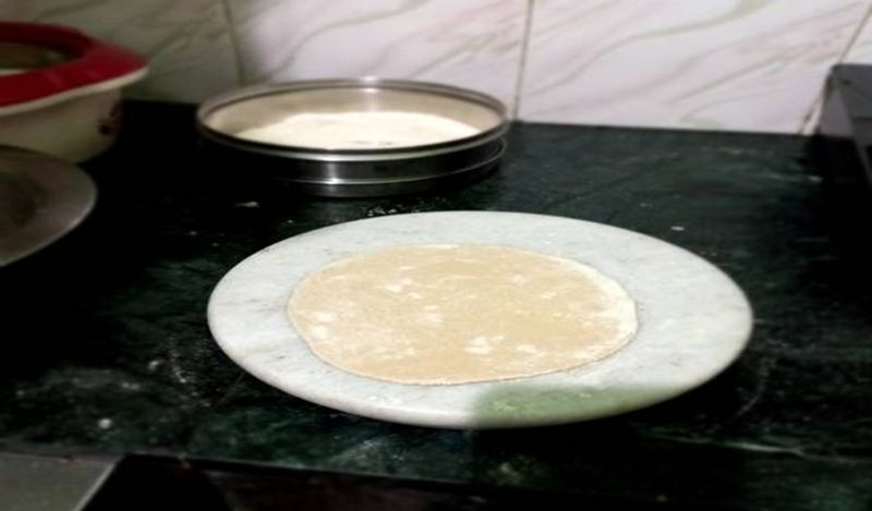 अब इसपर सूखा आटा लगाएं और लगातार बेलते रहे।
