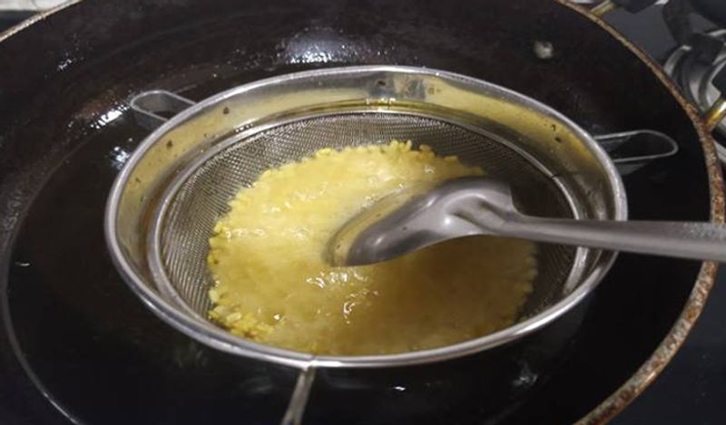इस छलनी पर मूंग दाल डालें और उसे अच्छे से मीडियम फ्लेम पर फ्राई करें।
