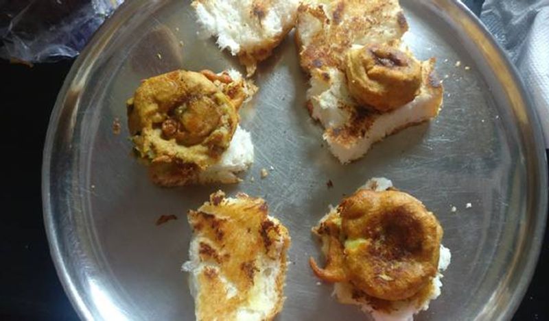 इन पाव में अब आलू के वडे डालें और हलके हाथ से दबा लें। 
