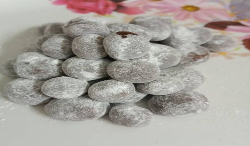 जब मिश्रण ठंडा हो जाए तो इसकी गोलियां बना दें। अब गोलियों के ऊपर चीनी का बुरादा लगा दें। 