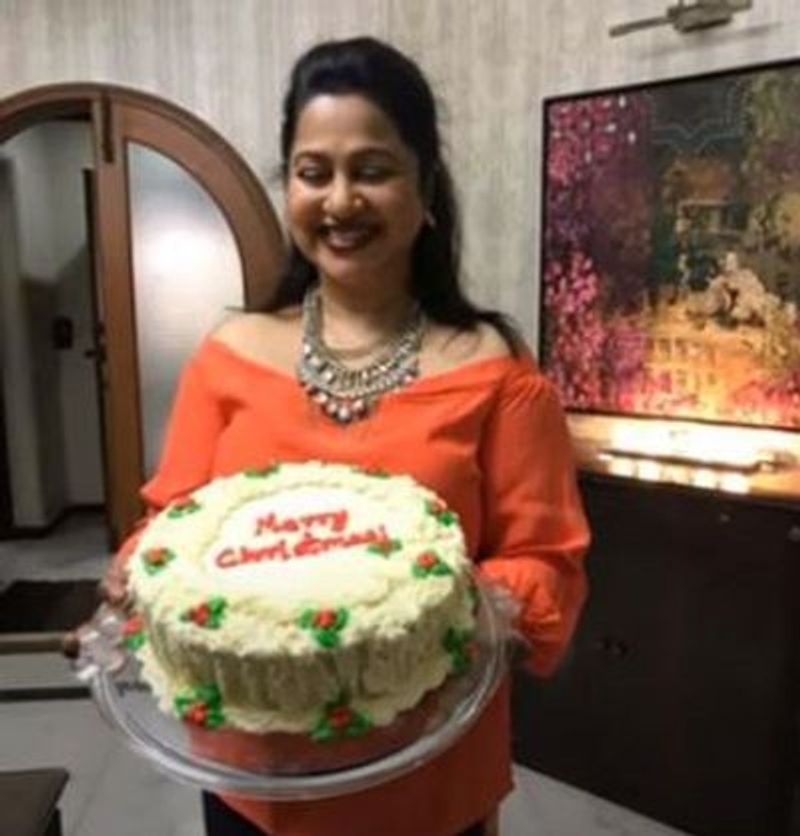 చేతిలో కేక్తో రాధిక చిరునవ్వులు చిందిస్తున్న ఈ స్థలం ఇంటి హాల్