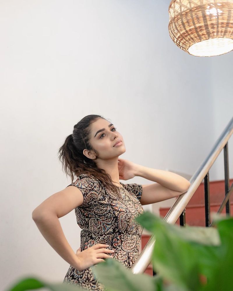 வீட்டு படிக்கட்டில் நின்று போஸ் கொடுக்கும் மீனாட்சி 