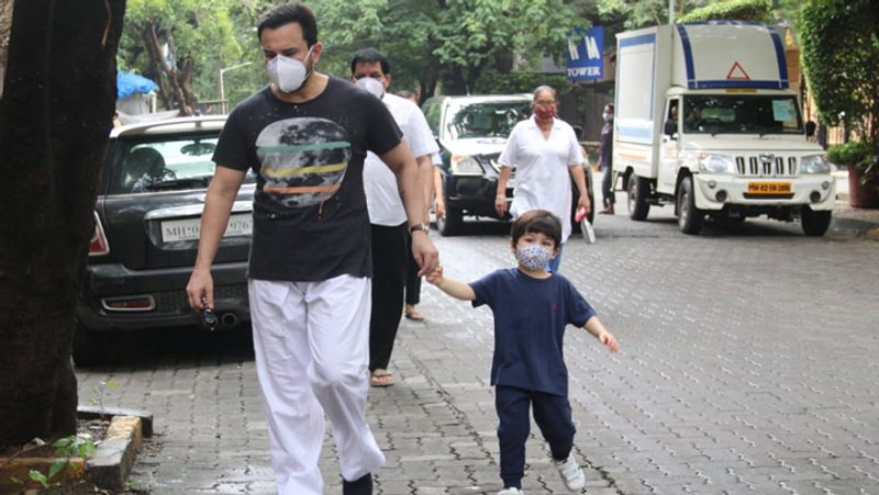Taimur ali khan walking on road holding papa saif ali khan hands but he was looking somewhere else KPJ