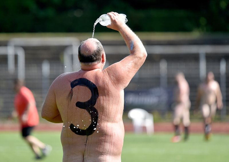 nude players play football in protest against corporate