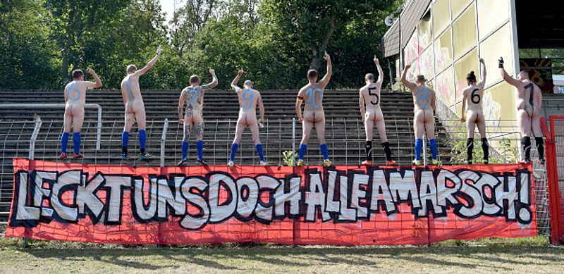 nude players play football in protest against corporate