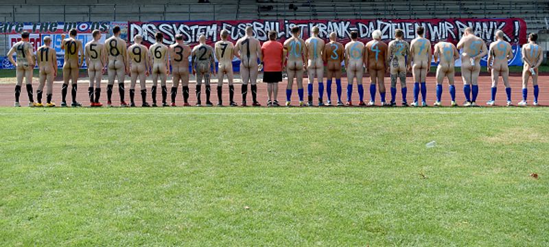 nude players play football in protest against corporate