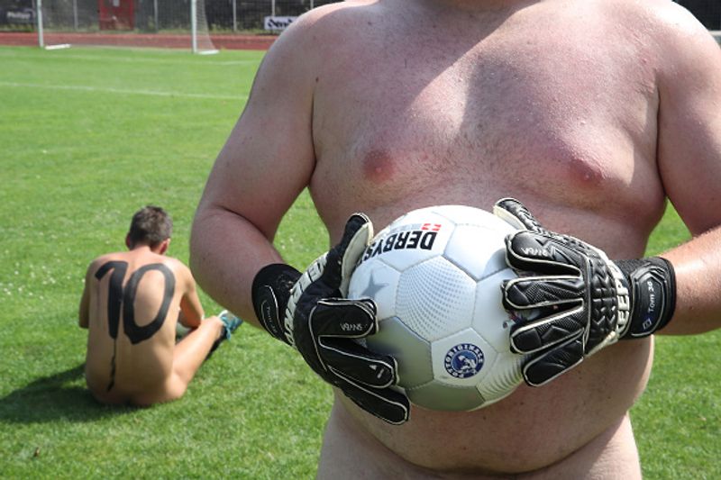 nude players play football in protest against corporate