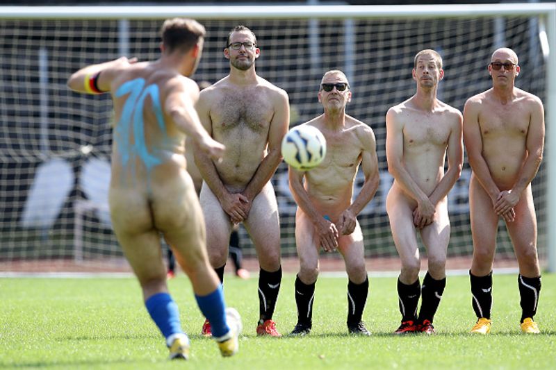 nude players play football in protest against corporate