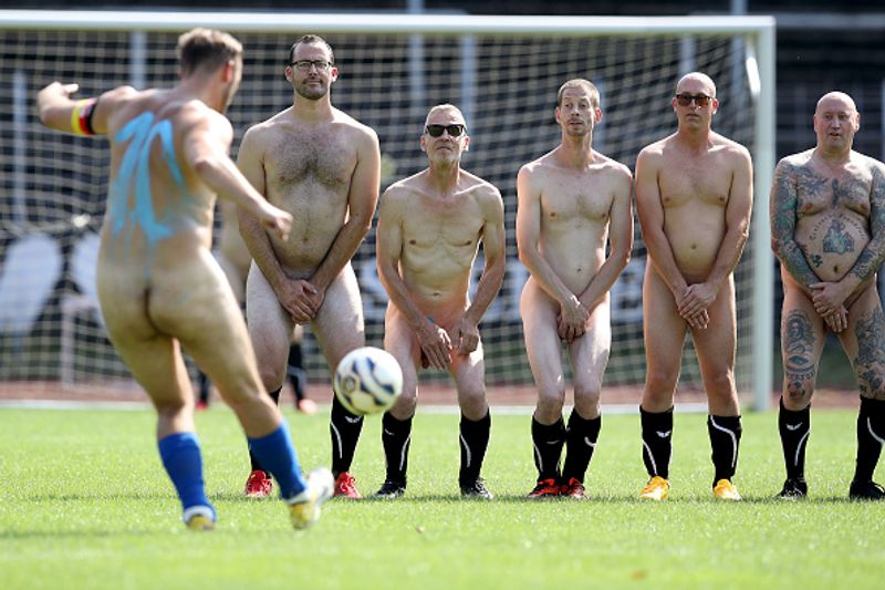 nude players play football in protest against corporate
