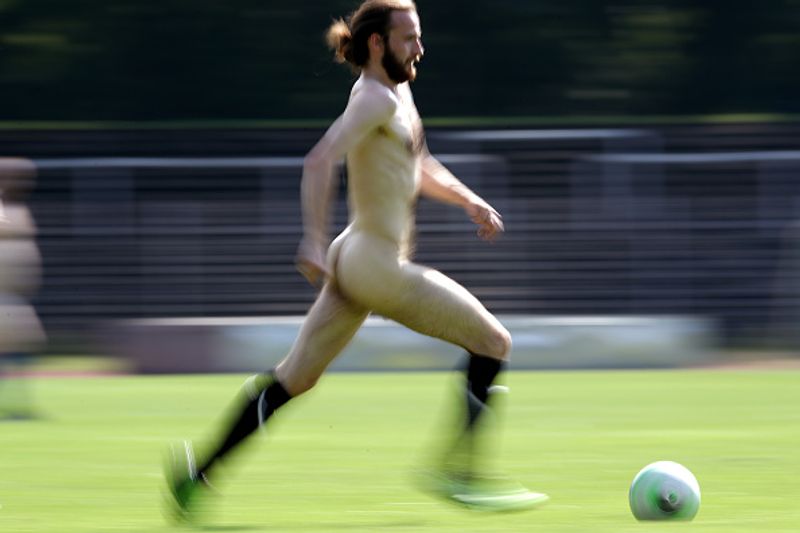 nude players play football in protest against corporate