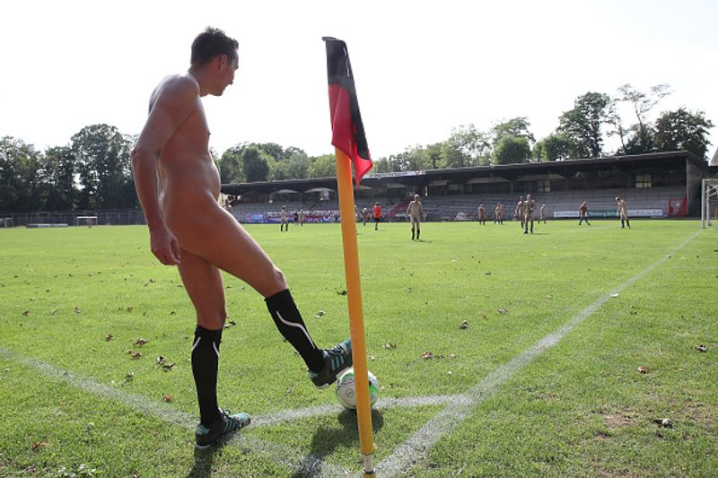 nude players play football in protest against corporate