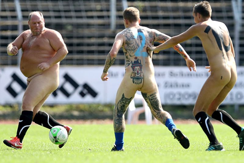 nude players play football in protest against corporate