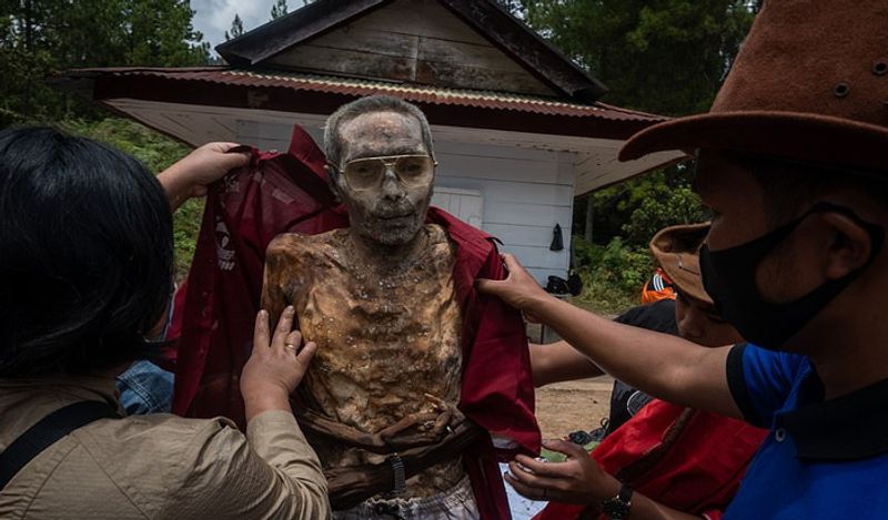 Indonesia Toraja Death Ritual where families dig dead relatives every year in august kph