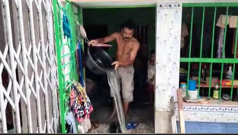 এই ব্যক্তি কোনও ঘরের কলের জন গামলায় করে ফেলছেন না। ঘরে মেঝে জলের তলায়। সেই জলই গামলা দিয়ে টেনে তুলে বাইরে ফেলছেন। এদিকে আবার বৃষ্টি শুরু হলে ফের জলে ভরে যাচ্ছে।